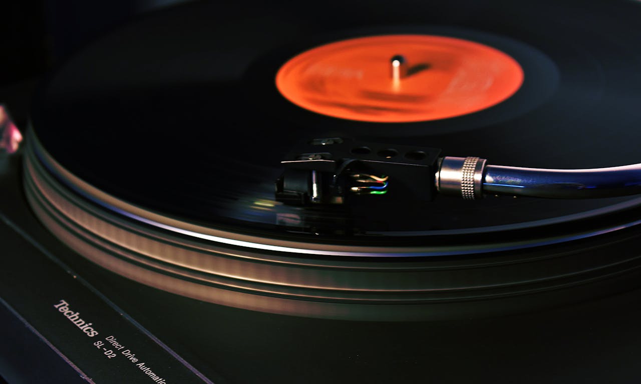 Close-up image of a vintage turntable playing a vinyl record, showcasing analog technology.