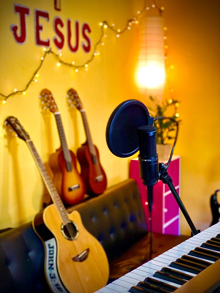 A warm room featuring guitars, keyboard, and microphone, ideal for music and worship.
