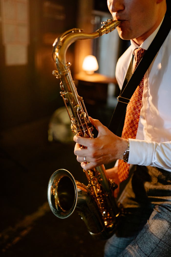 A man plays a saxophone indoors, creating an intimate jazz atmosphere.